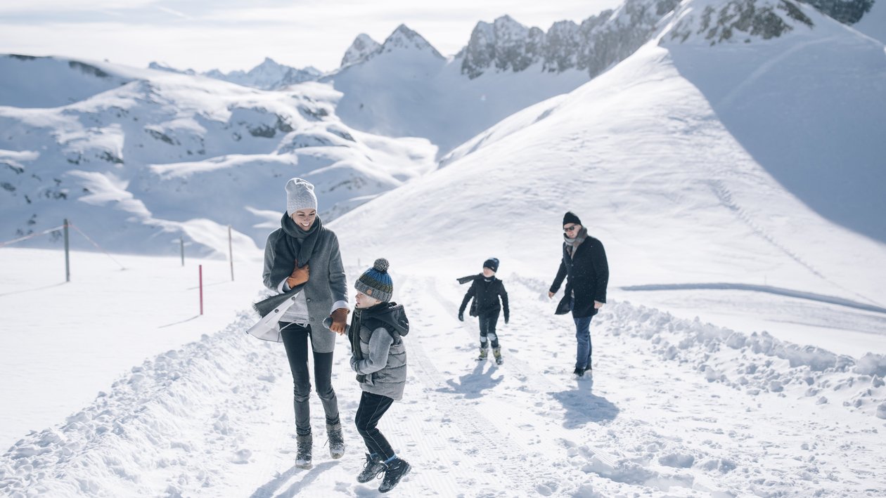 Familie beim Spaziergang durch die verschneite Arlberglandschaft © Daniel Zangerl - Lech Zürs Tourismus